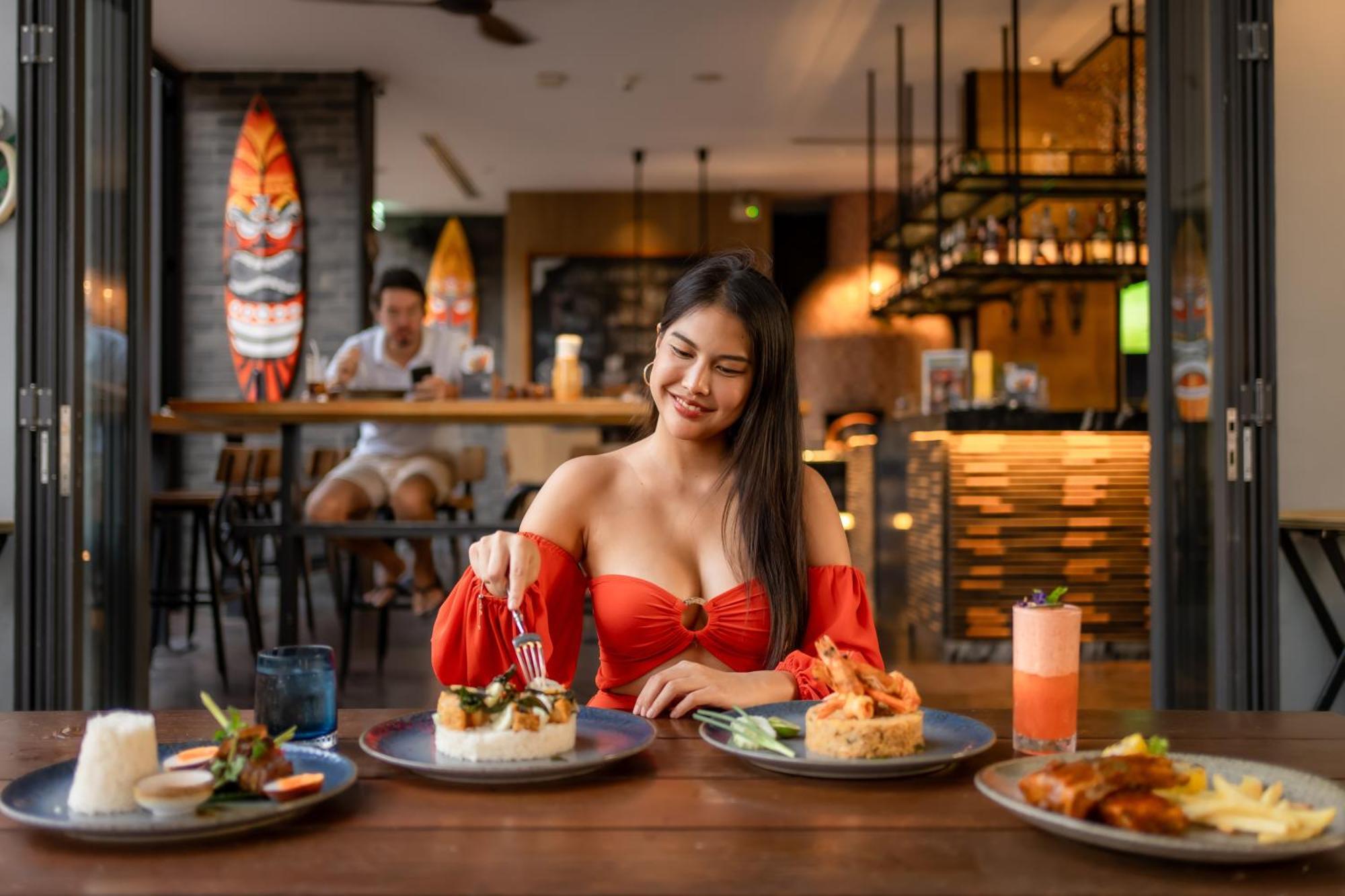 ホテル インディゴ プーケット パトン エクステリア 写真 A woman eating at a restaurant